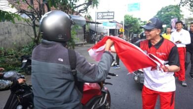 Bupati Klungkung, I Made Satria saat membagikan Bendera Merah Putih