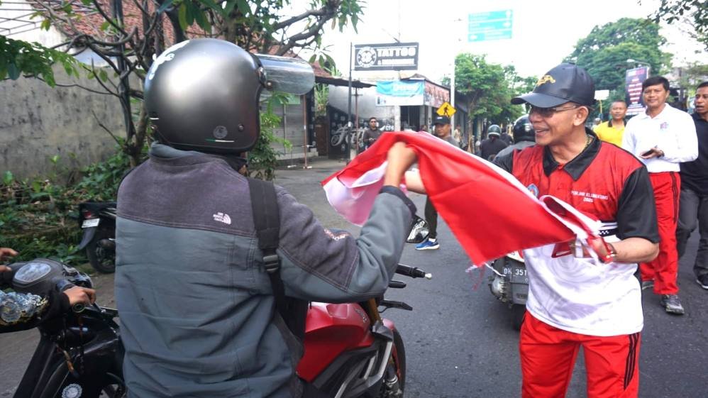 Bupati Klungkung, I Made Satria saat membagikan Bendera Merah Putih